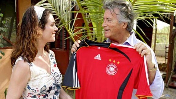 Elena schenkt Olivier ein Trikot der deutschen Nationalmannschaft.