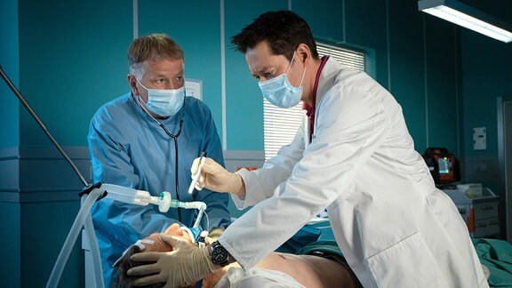 Zwei Ärzte untersuchen einen Patienten.