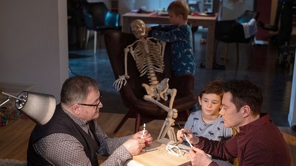 Dr. Philipp Brentano und Hans-Peter Brenner basteln mit Oskar und Max an einem Skelett.