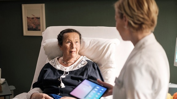 Jutta Weichsel (Doris Buchrucker, li.) im Krankenzimmer mit Dr. Kathrin Globisch (Andrea Kathrin Loewig, re.).