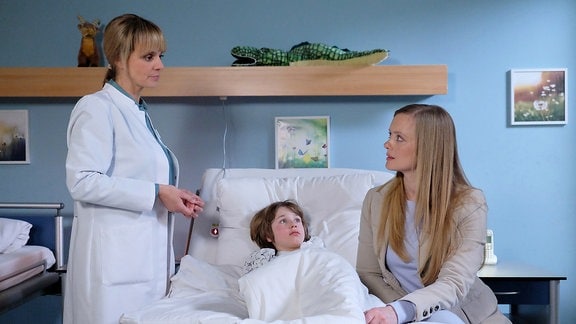Dr. Lea Peters spricht mit Matti und seiner Mutter im Krankenzimmer.