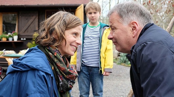 Katja Brückner lacht  Dr. Roland Heilmann an. Hannosteht im Hintergrund.