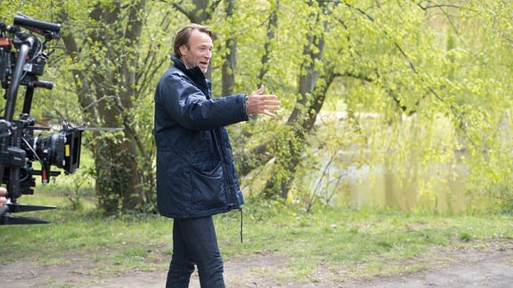 Bernhard Bettermann lacht bei Dreharbeiten im Park