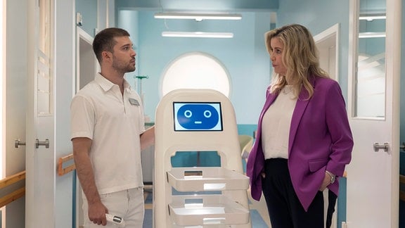 Sarah Marquardt (Alexa Maria Surholt) erwischt Kris Haas (Jascha Rust) auf frischer Tat. Sie hat angewiesen, die Finger vom neuen Pflegeroboter zu lassen, bis ein Fachmann ihn programmiert hat.