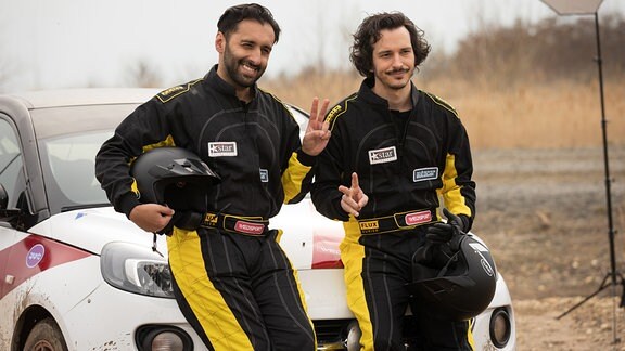 Cem Günez (Omar Akbar, li.) hat seinen Bruder Ali (Ferdi Özten, re.) zu einem Fotoshooting für die kommende Rallye-Saison überredet.