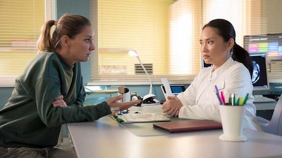 Serie: "In aller Freundschaft": Ärztin am Schreibtisch im Gepräch mit Patientin.