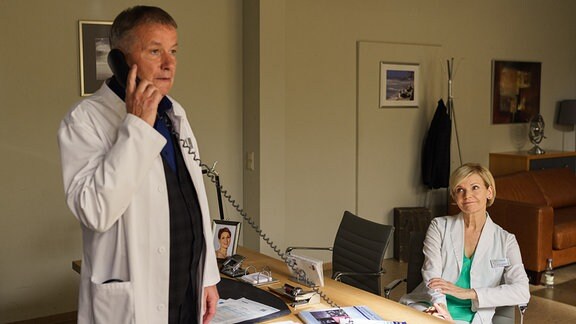 Dr. Roland Heilmann am Telefon. Kathrin Globisch sitzt daneben.