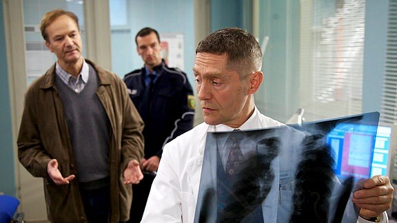 Dr. Rolf Kaminski (Udo Schenk, re.) traut seinen Ohren nicht, als Oberkommissar Erich Gassmann (Arnfried Lerche, li.) ihm sagt, dass ein Patient Anzeige gegen ihn erstattet hat.