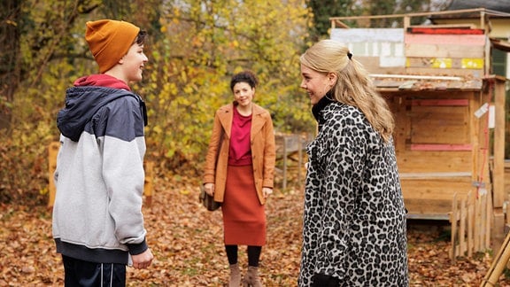 Ein Junge (Max Bär) aus dem Kinderheim führt Miriam (Christina Petersen, re.) und Rieke (Liza Tzschirner, mi.) ein wenig übers Gelände, während die beiden auf ihre mögliche neue Pflegetochter warten.