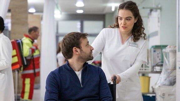 Während Pflegerin Jasmin Hatem (Leslie-Vanessa Lill) Mikael Helvi (Jonas Minthe) zum CT fährt, versucht er sie unverblümt über seine Ex-Freundin Dr. Lilly Phan auszufragen.