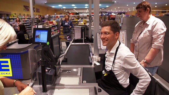 Ostbeauftragter Christian Hirte (CDU) als Kassierer in einem Thüringer Supermarkt