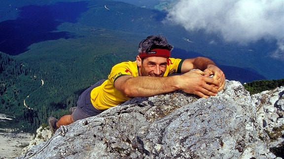 Ein Bergsteiger beim Freeclimbing an einer steilen Felswand des Hochstaufens bei Bad Reichenhall