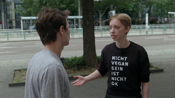 Eine junge Frau trägt ein Oberteil mit der Aufschrift "Nicht vegan sein ist nicht Ok".