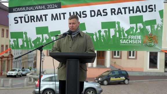 Ein Mitglied der freien Sachsen spricht auf einer Veranstaltung auf einem Marktplatz.