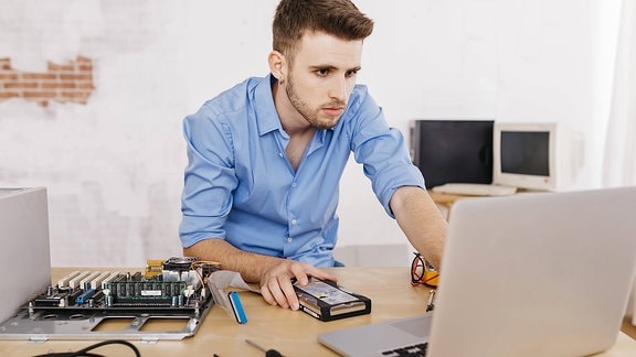 Ein junger Mann vor einem Laptop 