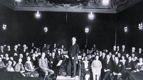 Schwarz-Weiß-Foto des Dirigenten Alfred Szendrei mit dem Leipziger Sinfonieorchester und dem Rundfunkchor in der Alten Handelsbörse.