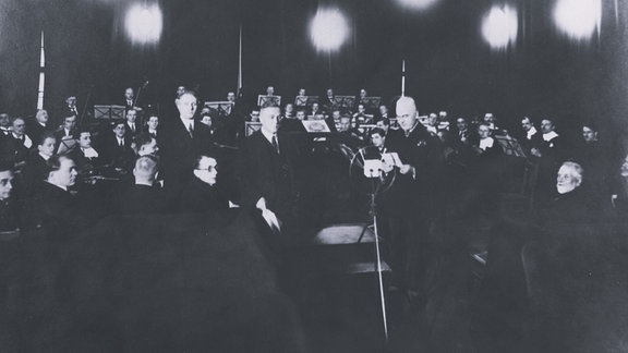 Schwarz-Weiß-Foto des Dirigenten Alfred Szendrei mit dem LSO im Sendesaal Alte Börse Leipzig