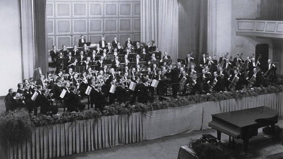 Schwarz-Weiß-Foto des Rundfunk Sinfonieorchesters mit seinem Dirgenten Gerhard Pflüger.