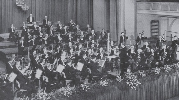 Schwarz-Weiß-Foto des Großen Rundfunkorchesters mit seinem Dirgenten Adolf Fritz Guhl.