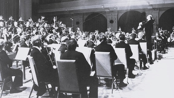 Schwarz-Weiß-Foto des Dirigenten Wolf-Dieter Hauschild bei Proben zu einer Fernseh-Übertragung des Rundfunk-Sinfonieorchesters in der Leipziger Kongresshalle am 15. und 16. Oktober 1979.