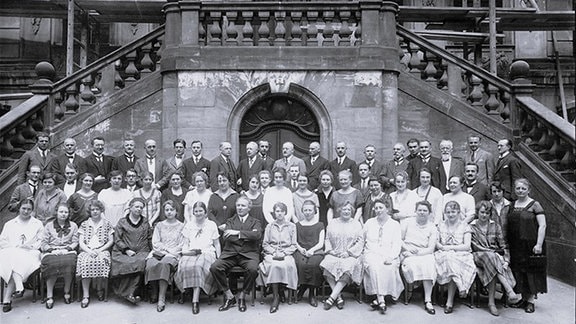 Schwarz-Weiß-Foto von Alfred Szendrei mit dem Rundfunkchor vor der Alten Börse in Leipzig.