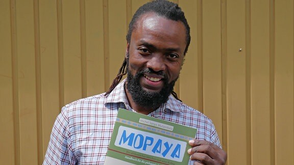 Der Musiker und Autor Michel Sanya Mutambala mit seinem Buch "Mopaya"