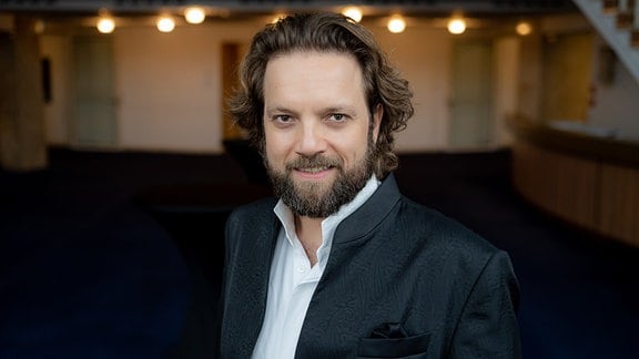 Tenor Mirko Roschkowski in einem schwarzen Anzug mit weißem Hemd