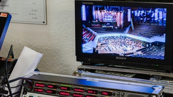 Bildschirm und Regiepult hinter den Kulissen beim Festkonzert zum 100. Geburtstag der MDR-Ensembles