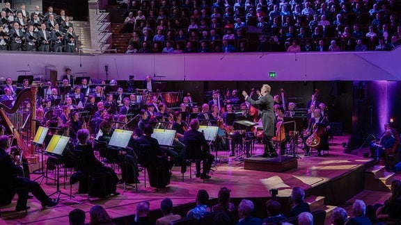 Philipp Ahmann dirigiert MDR-Sinfonieorchester und MDR-Rundfunkchor auf der Bühne des Leipziger Gewandhauses beim Festkonzert zum 100. Geburtstag der MDR-Ensembles