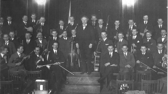 Historisches Schwarz-weiß-Bild zeigt das Leipziger Sinfonieorchester (LSO) mit Dirigent Alfred Szendrei in der Alten Handelsbörse in Leipzig in den 1920er Jahren.