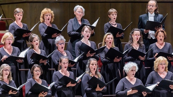 Die Damen des MDR-Rundfunkchors singen mit geöffneten Chormappen in den Händen.