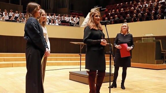 Vier Frauen auf der Bühne des Leipziger Gewandhauses: MDR-Kinderchor-Managerin Shafagh Aghaei (2. v. r.), zwei Chormitglieder, Journalistin Petra Mewes (r.).