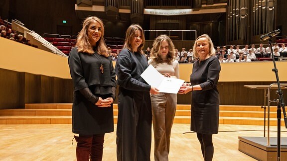 Vier Frauen auf der Bühne des Leipziger Gewandhauses: MDR-Kinderchor-Managerin Shafagh Aghaei, zwei Chormitglieder, Journalistin Petra Mewes (v. l. n. r.).