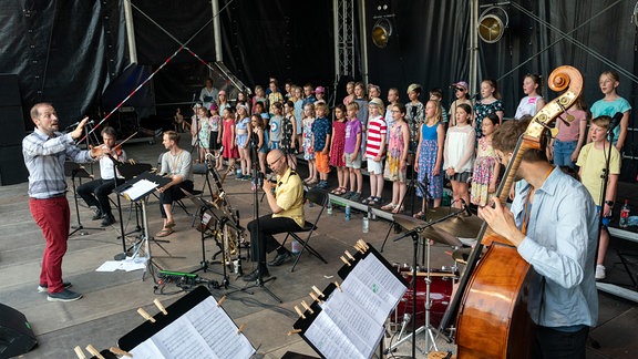 MDR-Kinderchor und Musiker in bunter Kleidung auf der Bühne