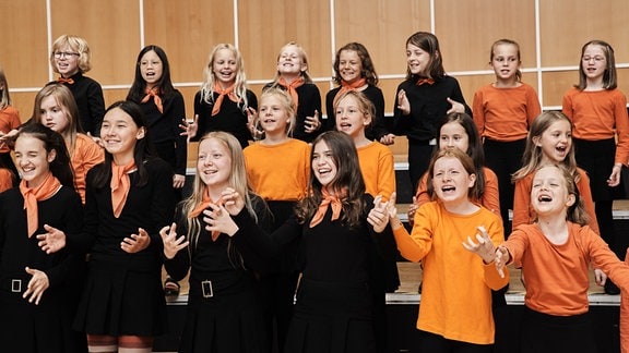 Die jungen Sängerinnen und Sänger des MDR-Kinderchors lachend in Aktion