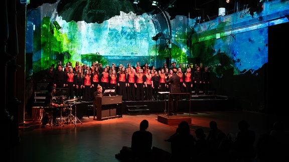 MDR-Kinderchor beim Konzert "Klanglabor" in der Schaubühne Lindenfels Leipzig, im Hintergrund bunte Projektionen auf der Wand