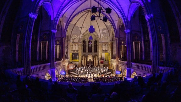Blick in die blau erleuchtete Leipziger Peterskirche bei der Uraufführung von James MacMillans Werk "Ordo Virtutum" im Nachtgesang am 26. Januar 2024.