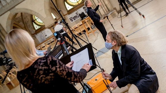 Mitglieder des MDR-Rundfunkchors stehen im großen Halbkreis in der Leipziger Peterskirche um Dirigent Philipp Ahmann und nehmen ein Werk von Michael Langemann auf.