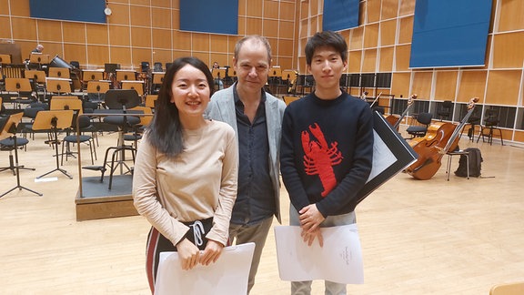 Dirigent Michael Wendeberg mit den Kompositionsstudierenden Haonan Guo und Zhaolong Sun