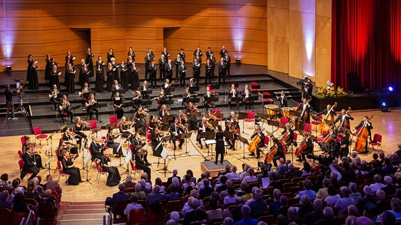Blick vom Publikumsraum auf die Bühne, wo MDR-Sinfonieorchester und MDR-Rundfunkchor beim Abschlusskonzert des MDR-Musiksommers in Suhl gemeinsam musizieren.