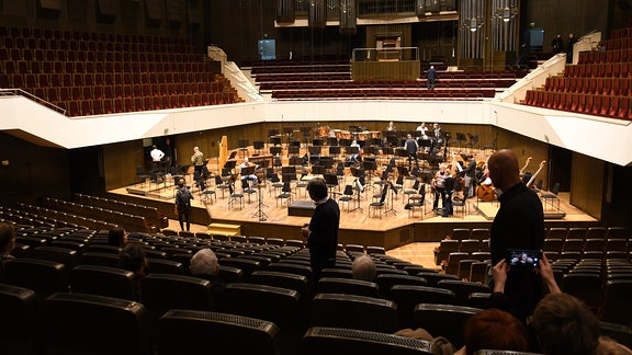 Im leeren Großen Saal des Gewandhauses sind einige Musiker des MDR-Sinfonieorchesters bereits auf der Bühne und bereiten sich auf die Probe vor. 