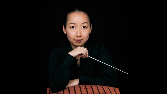 Die Dirigentin Nodoka Okisawa mit einem Taktstock