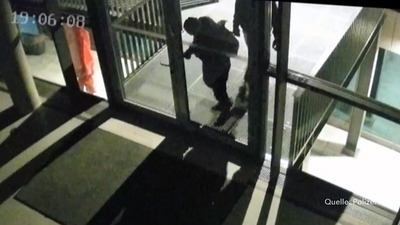 Zwei Täter beim Aufbrechen der Eingangstür des Multimediazentrums in Halle
