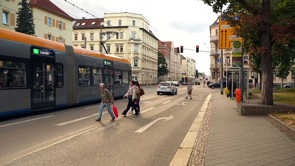 Straßenbahn an Haltestelle.