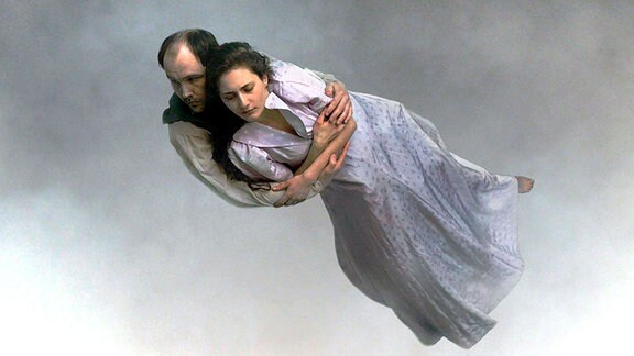 In einer Filmszene aus «Über die Unendlichkeit» scheint ein umschlungenes Paar durch die Luft zu fliegen.