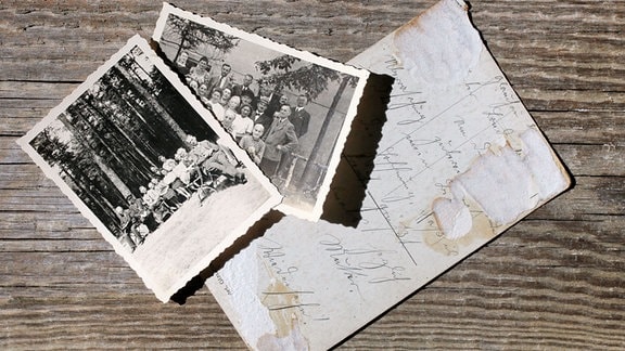 Symbolbild - Erinnerungen, Alte Fotos auf einer Holzplatte