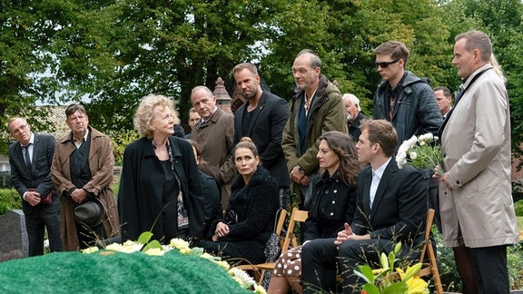 Szene aus der Serie "Das Begräbnis": eine Familie steht um ein Grab herum