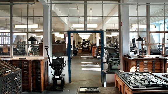 Blick ins Museum für Druckkunst Leipzig: in einem großen Raum stehen historische Druckgeräte