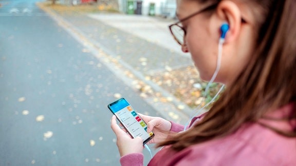 Junge Frau schaut auf Smartphone 