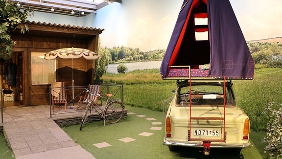 Trabant mit Camping-Aufsatz im August Horch Museum Zwickau, daneben ein Bungalow aus DDR-Zeiten 